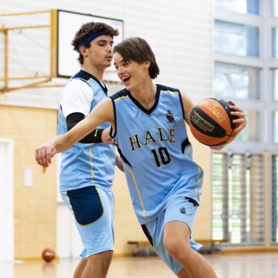 Boy dribbling past defender - basketball